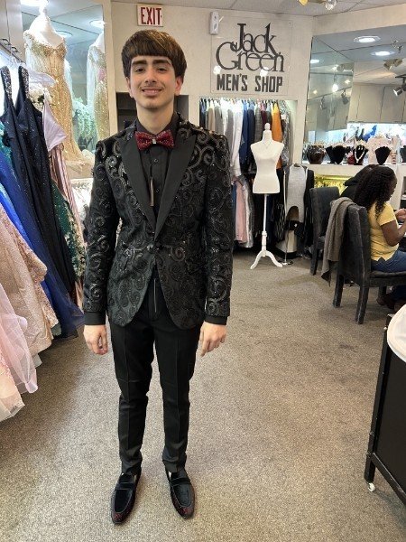 Young client in black baroque floral velvet blazer with red bow tie and black pants at Jack Green Men's Shop
