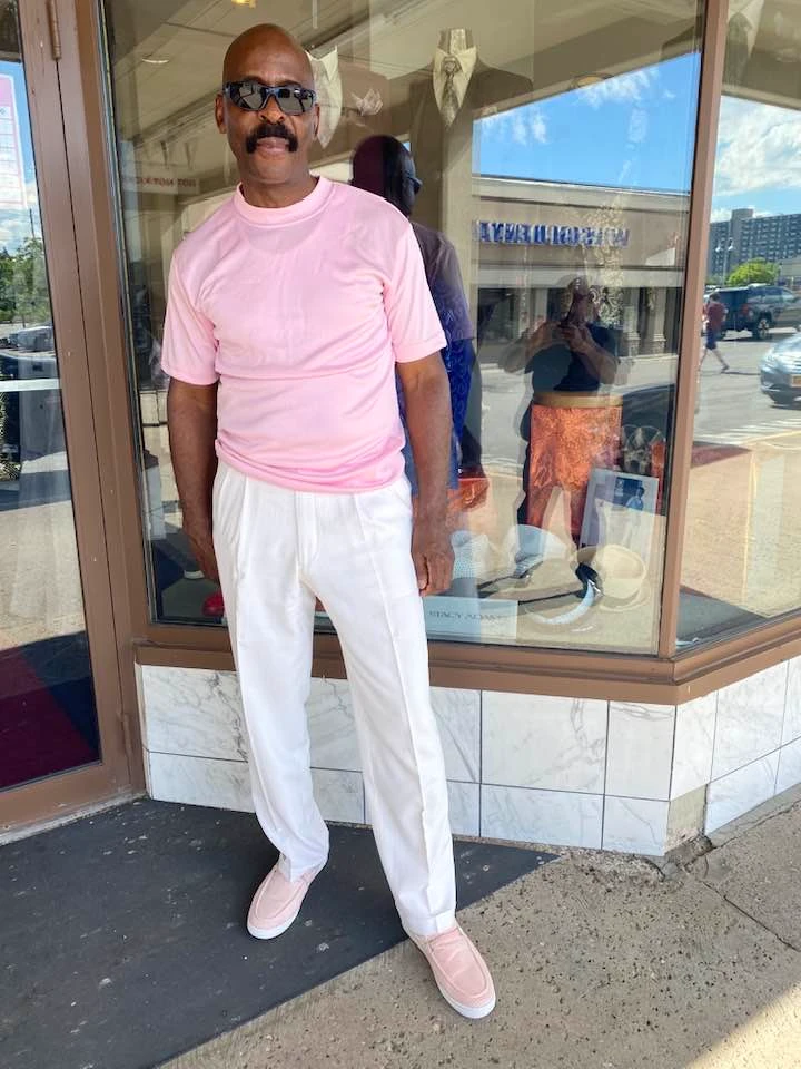 Adult client in casual pink shirt with white pleated pants and matching loafers