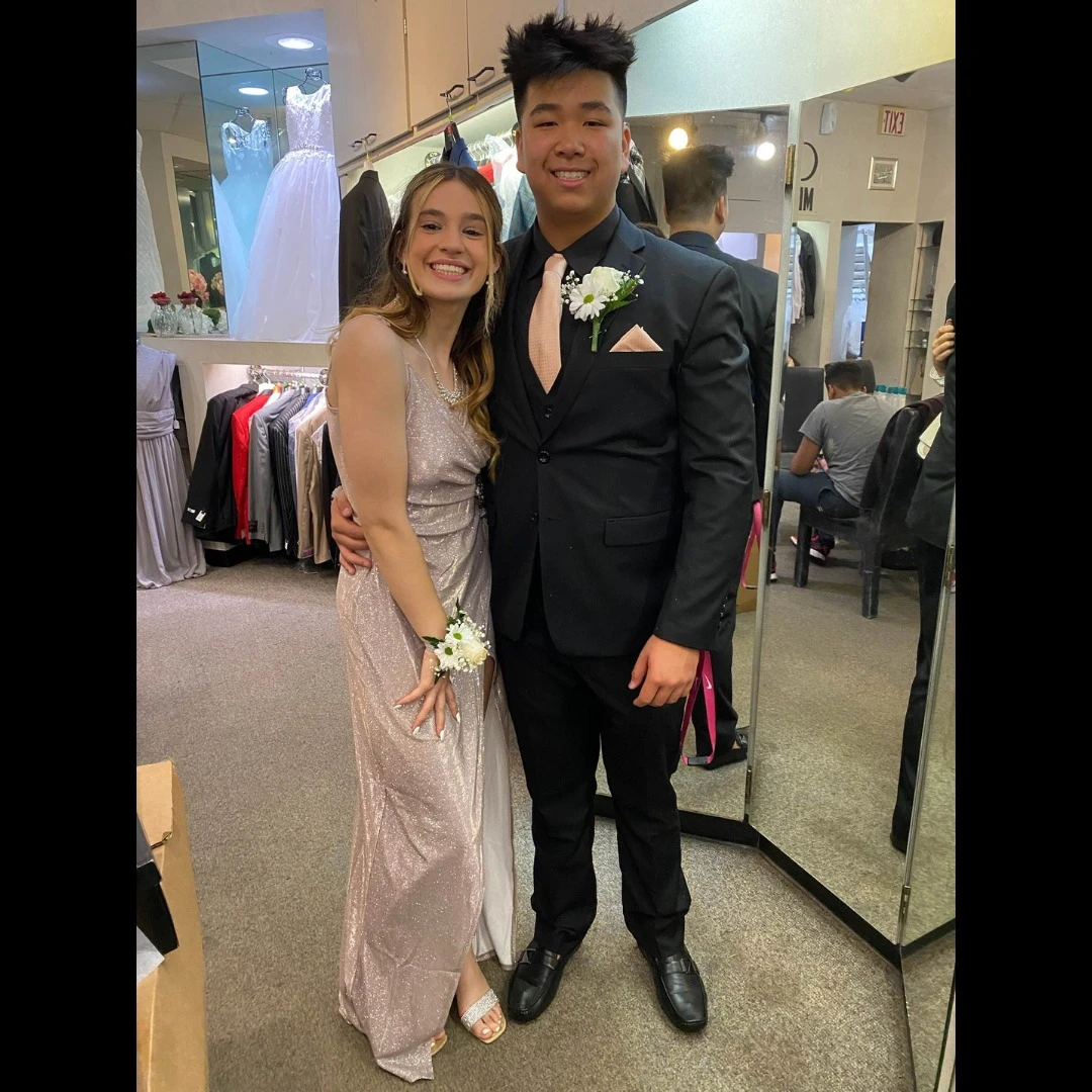 Prom couple - gentleman in black suit with pink tie and date in champagne dress