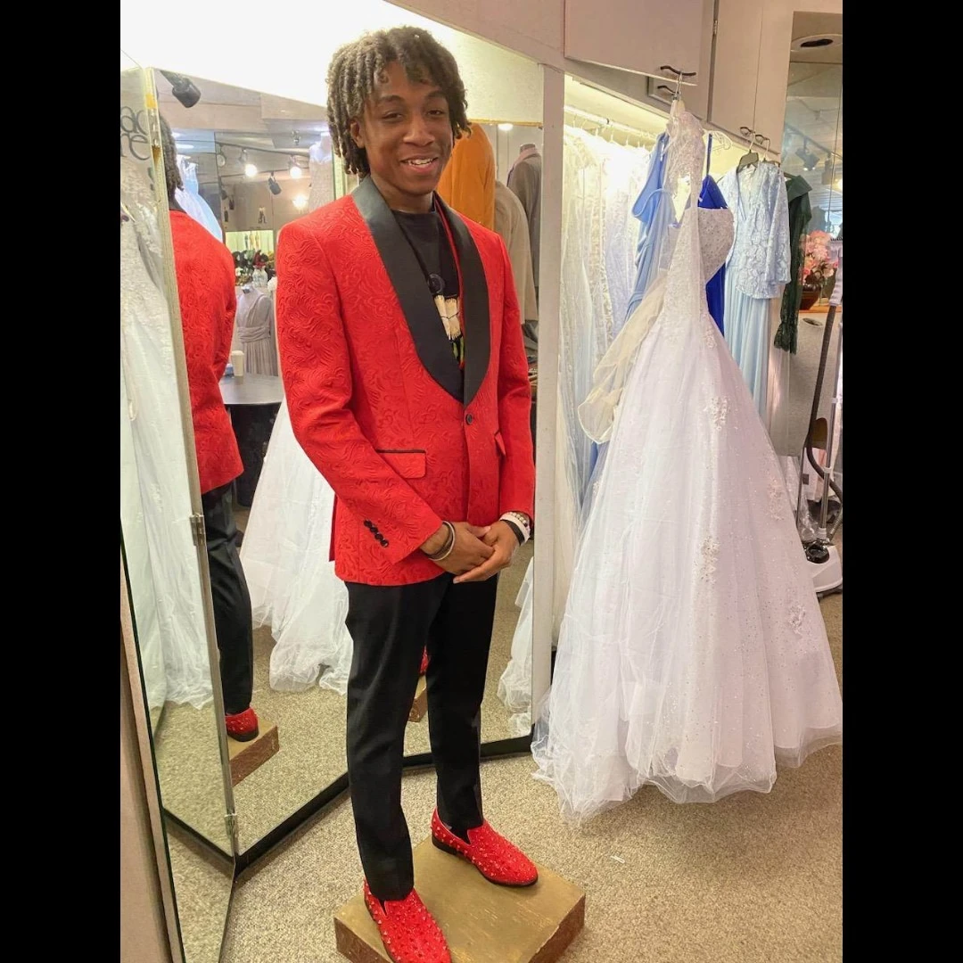 Client in red brocade blazer with black lapel and red crystal loafers