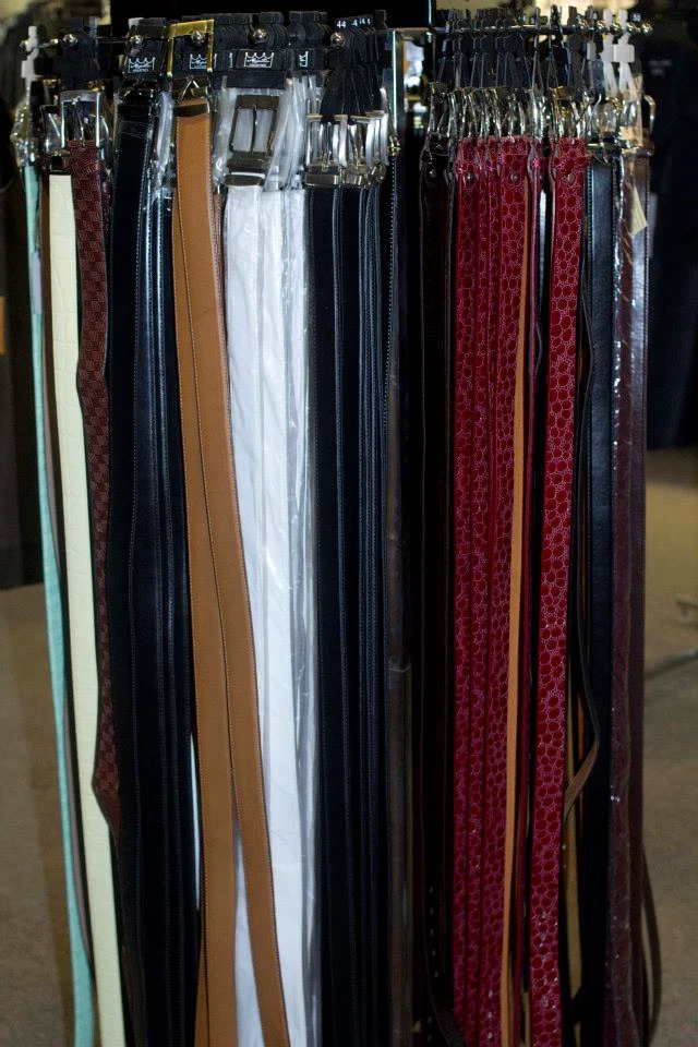 Belt rack display with leather belts in black, tan, white, and red
