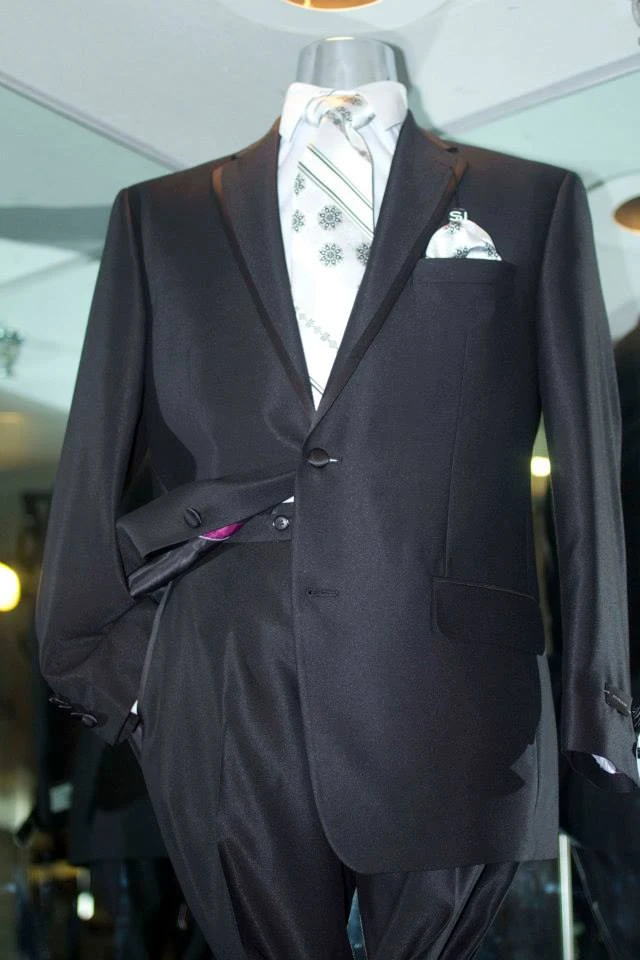 Black suit with white and green striped tie and pocket square