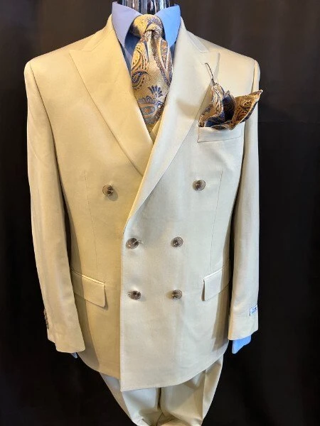 Cream double-breasted suit with peak lapel, blue dress shirt, gold and navy paisley tie, and matching pocket square at Jack Green Men's Shop