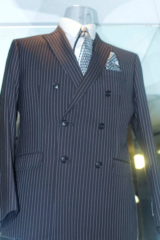 Navy pinstripe double-breasted suit with checkered tie and pocket square