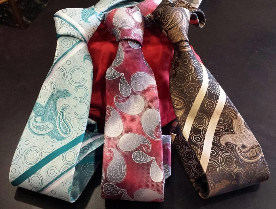 Three paisley ties in teal, magenta, and gold